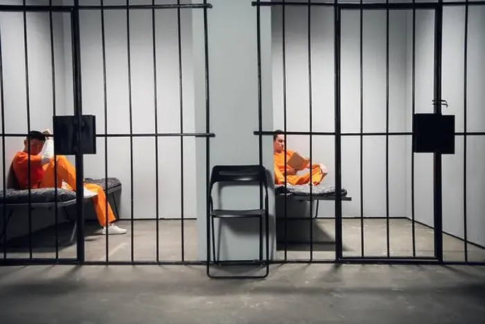 Framed Print : Prisoners in their cells are bored before lights out in prison. Read books. Symmetrical composition. Copy space Framed Print : Prisoners in their cells are bored before lights out in prison. Read books. Symmetrical composition. Copy space