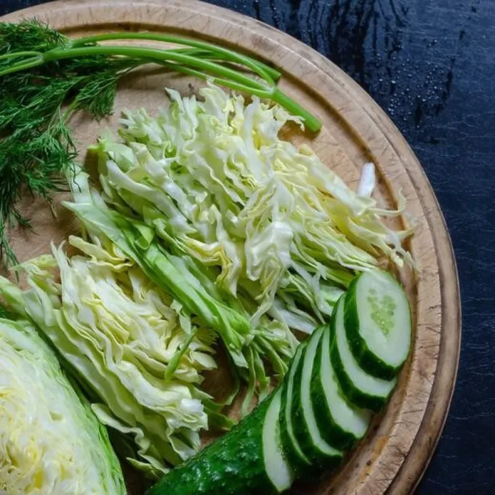 Framed Print : The process of making vegetable salad. Sliced fresh vegetables on a cutting board. Slaw white cabbage, cucumber and dill on a round cutting board. Sim Framed Print : The process of making vegetable salad. Sliced fresh vegetables on a cutting board. Slaw white cabbage, cucumber and dill on a round cutting board. Sim