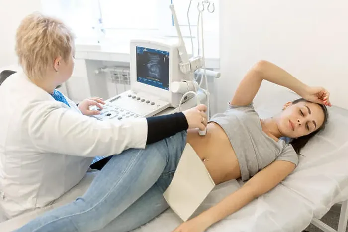 Framed Print : A professional doctor makes an ultrasound examination of a young girl who lies on a couch in the office Framed Print : A professional doctor makes an ultrasound examination of a young girl who lies on a couch in the office
