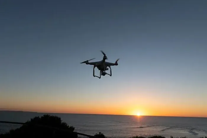 Framed Print : Professional Drone flying at Sunrise over the sea. The sky is glowing Framed Print : Professional Drone flying at Sunrise over the sea. The sky is glowing