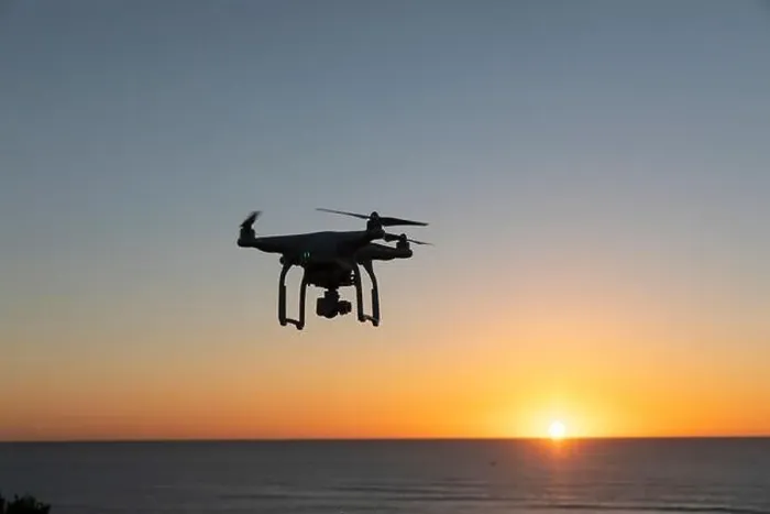 Framed Print : Professional Drone flying at Sunrise over the sea. The sky is glowing Framed Print : Professional Drone flying at Sunrise over the sea. The sky is glowing