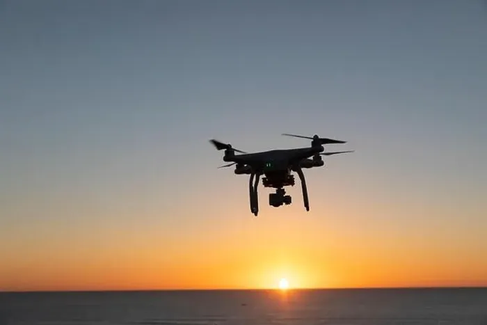 Framed Print : Professional Drone flying at Sunrise over the sea. The sky is glowing Framed Print : Professional Drone flying at Sunrise over the sea. The sky is glowing
