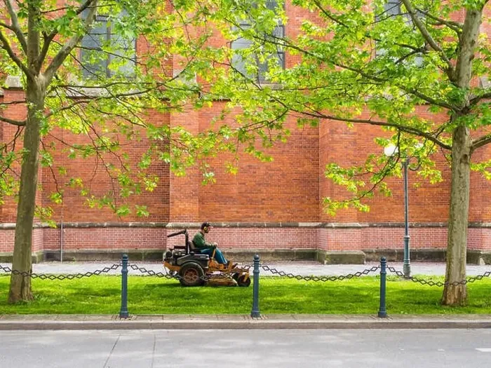 Framed Print : Public servise: Man on a mower cutting grass in the city Framed Print : Public servise: Man on a mower cutting grass in the city