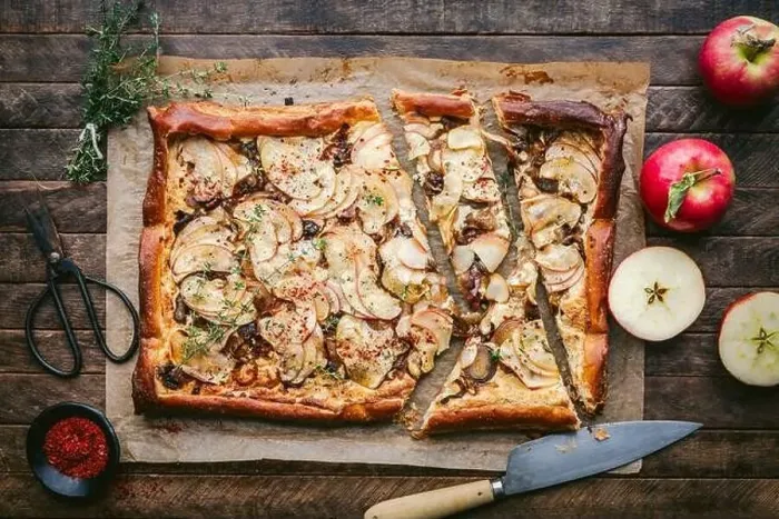 Framed Print : Puff Pastry tart with cheese, sliced apples and thyme on parchment with knife and fresh apples Framed Print : Puff Pastry tart with cheese, sliced apples and thyme on parchment with knife and fresh apples