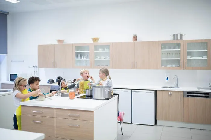 Framed Print : Pupils cooking together in cooking class