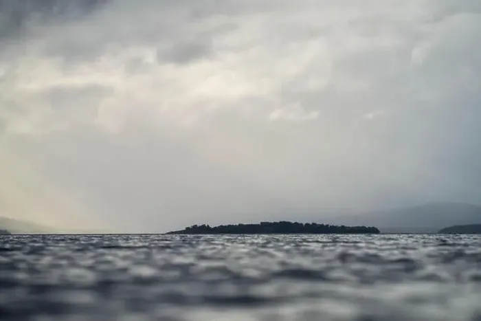 Framed Print : rays through clouds over the water