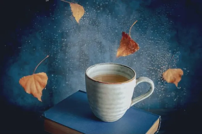 Framed Print : Reading in autumn, a still life with a cup of tea, falling leaves and raindrops, toned image Framed Print : Reading in autumn, a still life with a cup of tea, falling leaves and raindrops, toned image