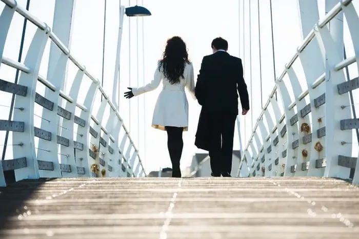 Framed Print : Rear view of two business people, man and woman, walking away over a bridge, UK Framed Print : Rear view of two business people, man and woman, walking away over a bridge, UK