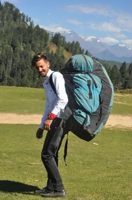 Framed Print : Rear view of a young male tourist walking with carrying parachute bag in the mountain Framed Print : Rear view of a young male tourist walking with carrying parachute bag in the mountain
