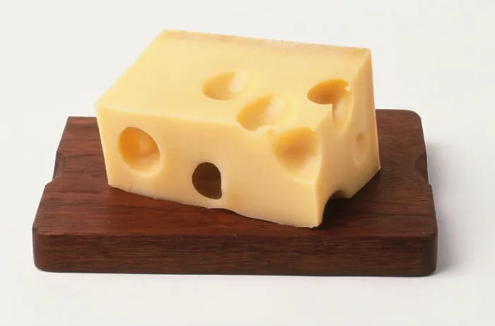 Framed Print : Rectangular block of cheese with holes on wooden board, close up Framed Print : Rectangular block of cheese with holes on wooden board, close up