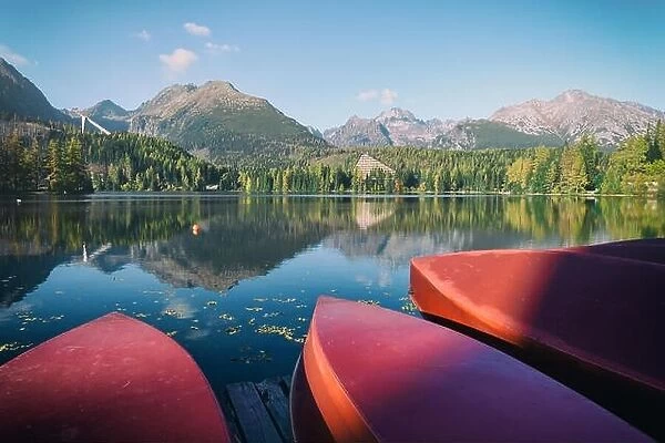 Red boats on Strbske Pleso lake. Location: High Tatras National Park, Slovakia. Instagram filter