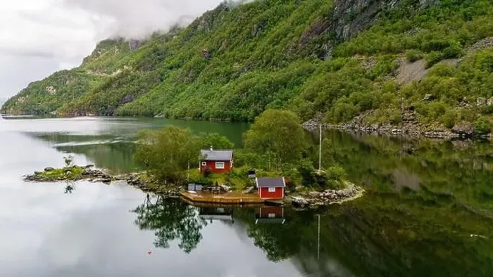 Framed Print : Two red cabins sit on a small island in a Norwegian fjord Framed Print : Two red cabins sit on a small island in a Norwegian fjord
