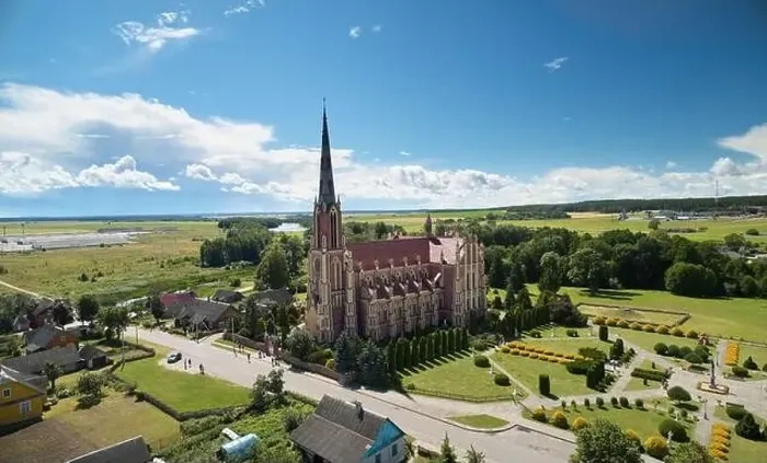 Framed Print : Red catholic church on blue sky background aerial view