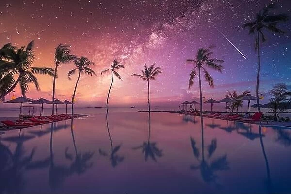 Reflection chairs around infinity swimming pool near sea ocean with palm trees beach at night sunset time. Lifestyle leisure carefree travel vacation
