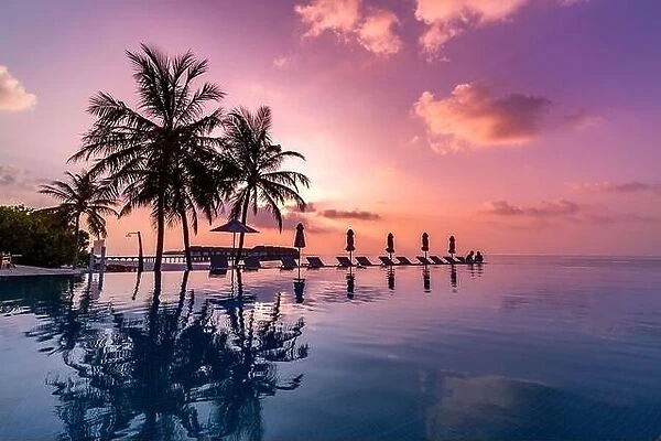 Relaxation infinity sunset pool in a luxurious beachfront hotel resort at tropical landscape. Luxury perfect beach holiday vacation background