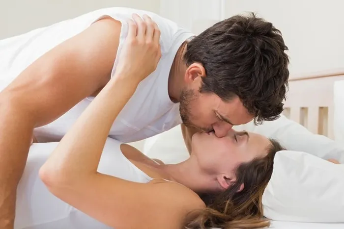 Framed Print : Relaxed young couple kissing in bed