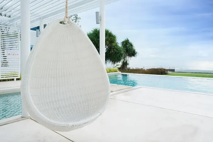 Framed Print : Relaxing white rattan hanging chair at swimming pool on sea view for vacation, summer and travel concept Framed Print : Relaxing white rattan hanging chair at swimming pool on sea view for vacation, summer and travel concept