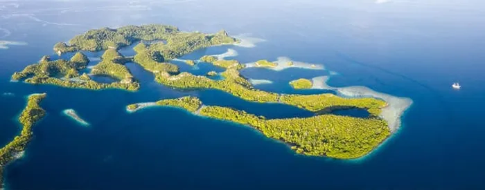 Framed Print : Remote limestone islands rise from the stunning seascape in Raja Ampat, Indonesia. This diverse region is known as the heart of the Coral Triangle