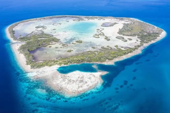 Framed Print : A remote tropical island in the Molucca Sea is fringed by mangrove forest surrounding a shallow lagoon. This island sits amid the Coral Triangle