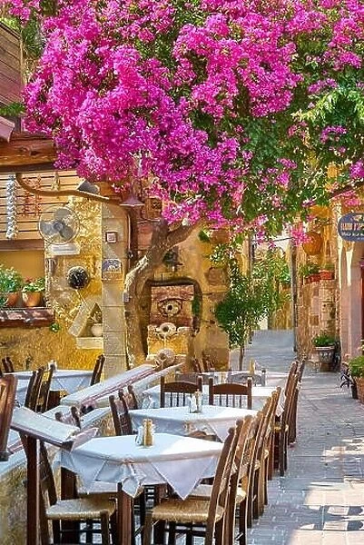 Restaurant at Chania Old Town, blooming bougainvillea flowers, Crete Island, Greece