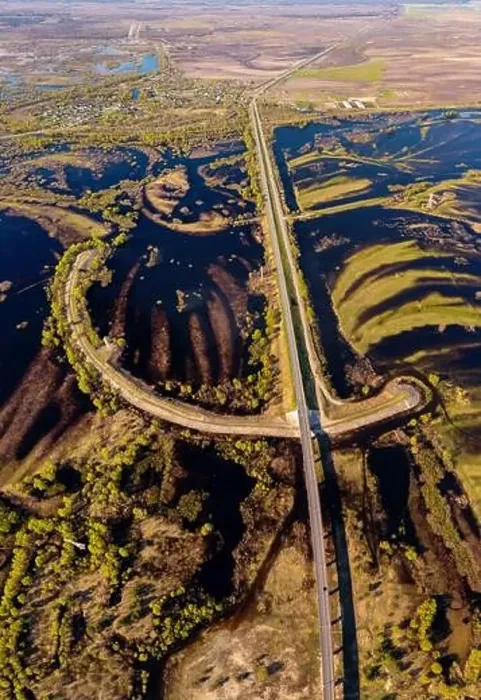 Framed Print : Road through flooded meadows in spring from above. Floodplains of river Pripyat shot from a drone Framed Print : Road through flooded meadows in spring from above. Floodplains of river Pripyat shot from a drone