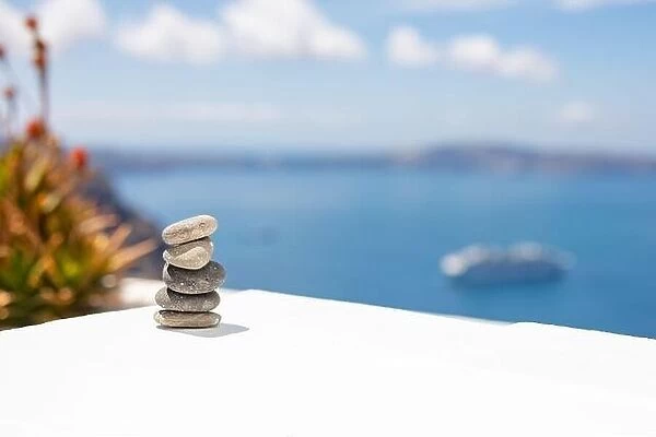 Rock zen pyramid of stones pebbles on the background of the sea and boat. Concept of Life balance, harmony and meditation. Pyramid of sea pebbles