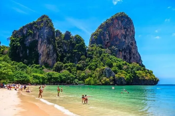 Framed Print : Rocks, water, tropical white sand beach and people swimming in emerald azure water of bay Framed Print : Rocks, water, tropical white sand beach and people swimming in emerald azure water of bay
