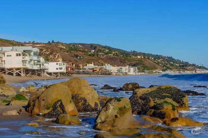 Framed Print : Rocky shoreline of Malibu Beach with cascading waves and coastal homes perched on the hillside Framed Print : Rocky shoreline of Malibu Beach with cascading waves and coastal homes perched on the hillside