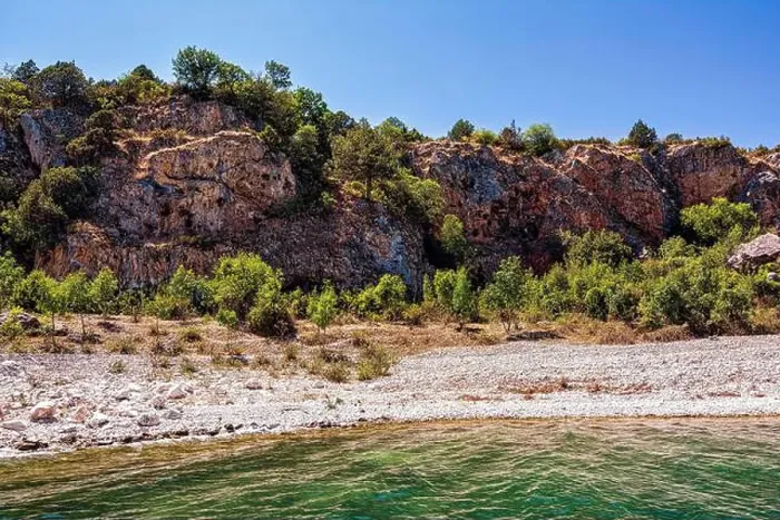 Framed Print : The rocky shoreline of Megali Prespa Lake in Greece