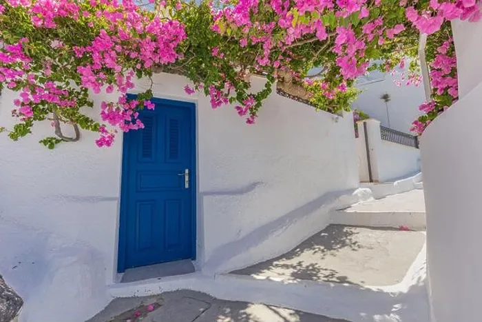Framed Print : Romantic blue door with pink flowers, idyllic nature. Couple honeymoon destination, urban street banner. Santorini, Greece