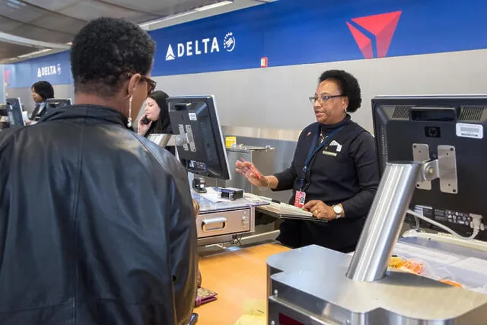 Framed Print : Romulus, Michigan - A Delta Air Lines ticket agent checks in a passenger at Detroit Metro Airport Framed Print : Romulus, Michigan - A Delta Air Lines ticket agent checks in a passenger at Detroit Metro Airport