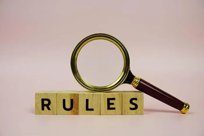 Framed Print : Rules with wooden blocks alphabet letters and Magnifying glass on pink background Framed Print : Rules with wooden blocks alphabet letters and Magnifying glass on pink background