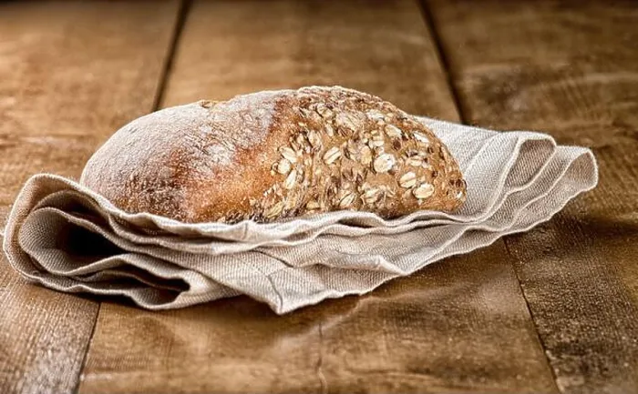 Framed Print : Rustic bread loaf with oats served on napkin on a wooden table Framed Print : Rustic bread loaf with oats served on napkin on a wooden table