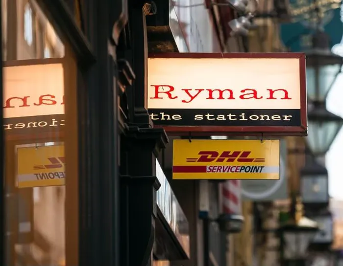 Framed Print : Ryman the stationer stationery store shop sign with window reflection, and DHL Service Point sign below, Birmingham, UK Framed Print : Ryman the stationer stationery store shop sign with window reflection, and DHL Service Point sign below, Birmingham, UK
