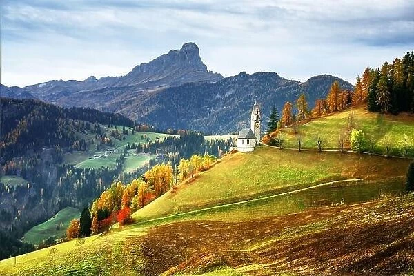 Santa Barbara church at the autumn Dolomite Alps. Amazing landscape with small chapel on sunny meadow at San Genesio village location