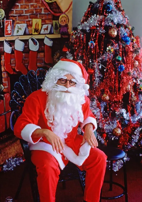 Framed Print : Santa Claus (Father Christmas) sitting in store setting by Christmas tree