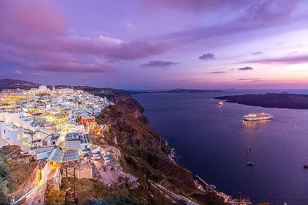 Santorini, Greece. Famous sunset view of traditional white architecture Santorini landscape with flowers in foreground. Summer vacation luxury travel