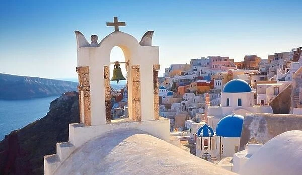 Santorini Island - greek church, bell tower and white houses in the background - Oia Town, Greece