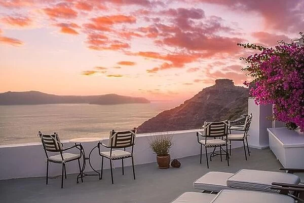 Santorini island sunset. Caldera view with chairs and flowers, romantic mood, couple travel vacation landscape destination scenic. Tourism romance