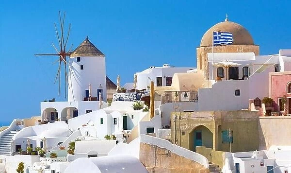 Santorini landscape with white houses, windmill and greek flag - Oia Town, Santorini Island, Cyclades, Greece