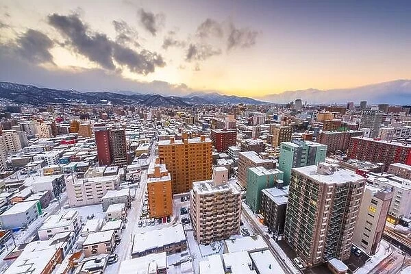 Sapporo, Hokkaido, Japan downtown cityscape towards the mountains at dusk in winter