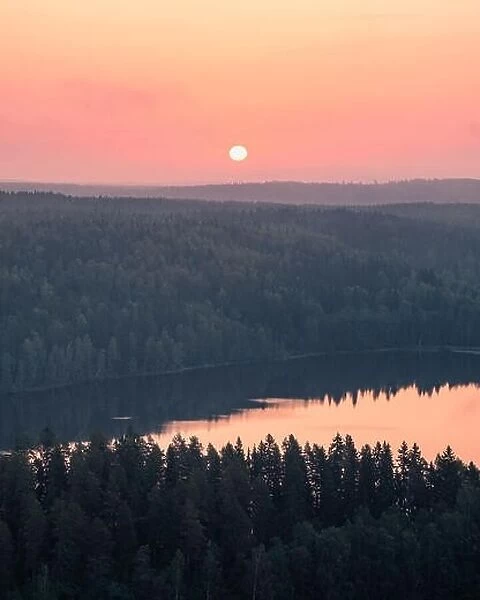 Scenic high angle landscape with sunrise, forest and lake at autumn morning in Finland