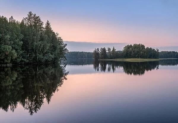 Scenic lake landscape with sunset and beautiful reflections at autumn evening in Finland