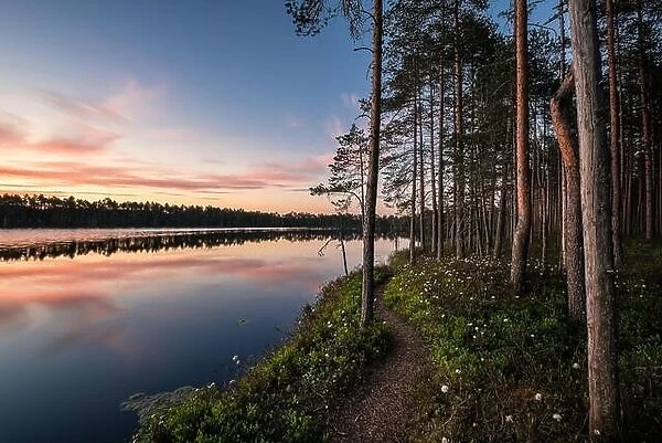 Scenic lake view with idyllic path and sunset at peaceful evening in National Park, Finland