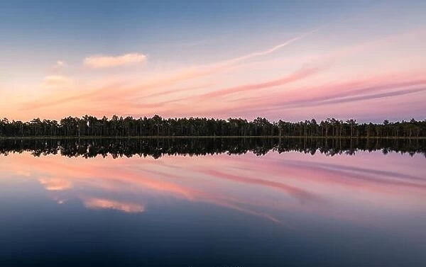 Scenic lake view with reflections and sunset at peaceful evening in National Park Finland
