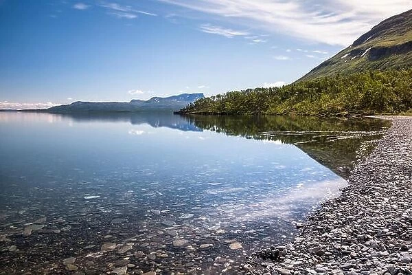 Scenic lake view with tranquil water at sunny summer day in Abisko, Sweden