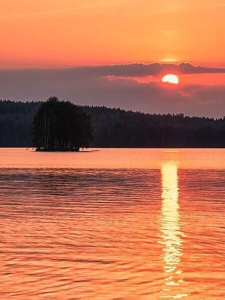 Scenic landscape with beautiful sunset and lake at summer evening in Finland