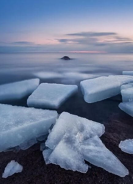 Scenic landscape with ice cubes and sunset at evening in Finland