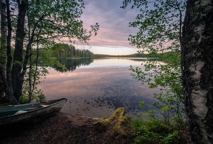 Framed Print : Scenic landscape with idyllic lake view and boat at summer evening in Finland Framed Print : Scenic landscape with idyllic lake view and boat at summer evening in Finland