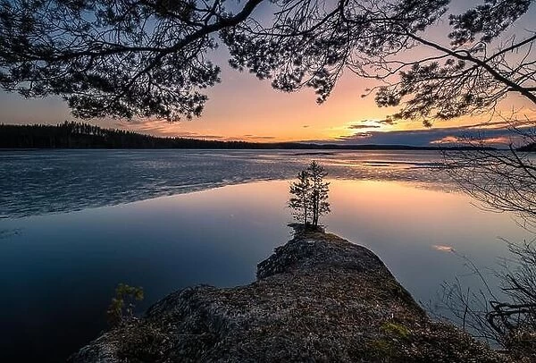 Scenic landscape with melting lake and sunset at beautiful spring evening in Finland